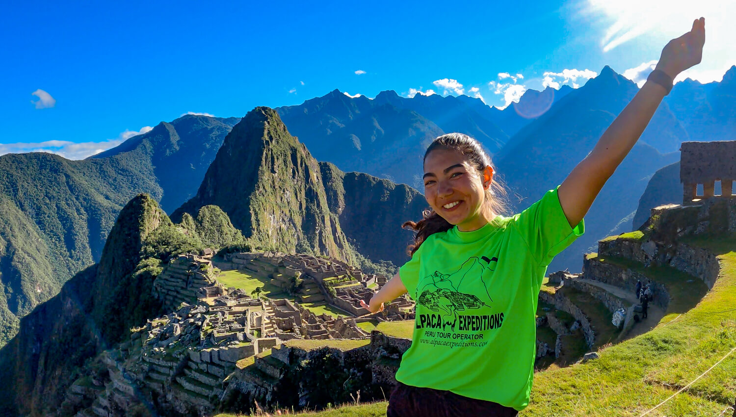 Woman poses in front of ruins on Sacred Valley and Machu Picchu Train Tour